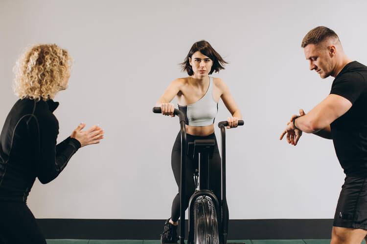 woman-exercising-on-air-bike-at-gym-with-friends-m-2023-04-03-22-29-20-utc (1) (1).jpg
