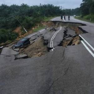 连日下雨致路面坍塌  轿车陷入大泥坑