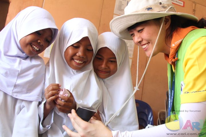 A Happy Move volunteer sharing a light moment with students from SK Kebagu.JPG