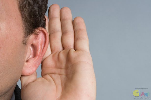 Caucasian man with hand cupped on ear listening.jpg