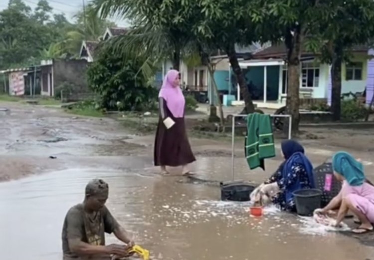 Jalan berlubang jadi tempat cuci baju